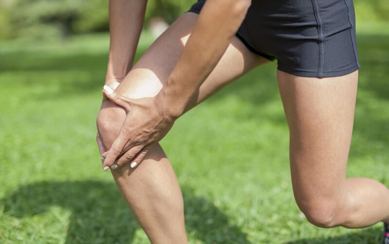 Man grabbing knee in pain due to patellar tendonitis, a condition rarely requiring knee surgery
